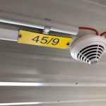 Brandmelder Bosch mit Schild in einer 11m hohen Lagerhalle